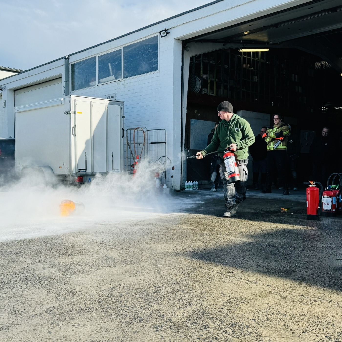 Leden van Castelein Landscaping tijdens een training op het bedrijfsterrein met brandblusapparaten