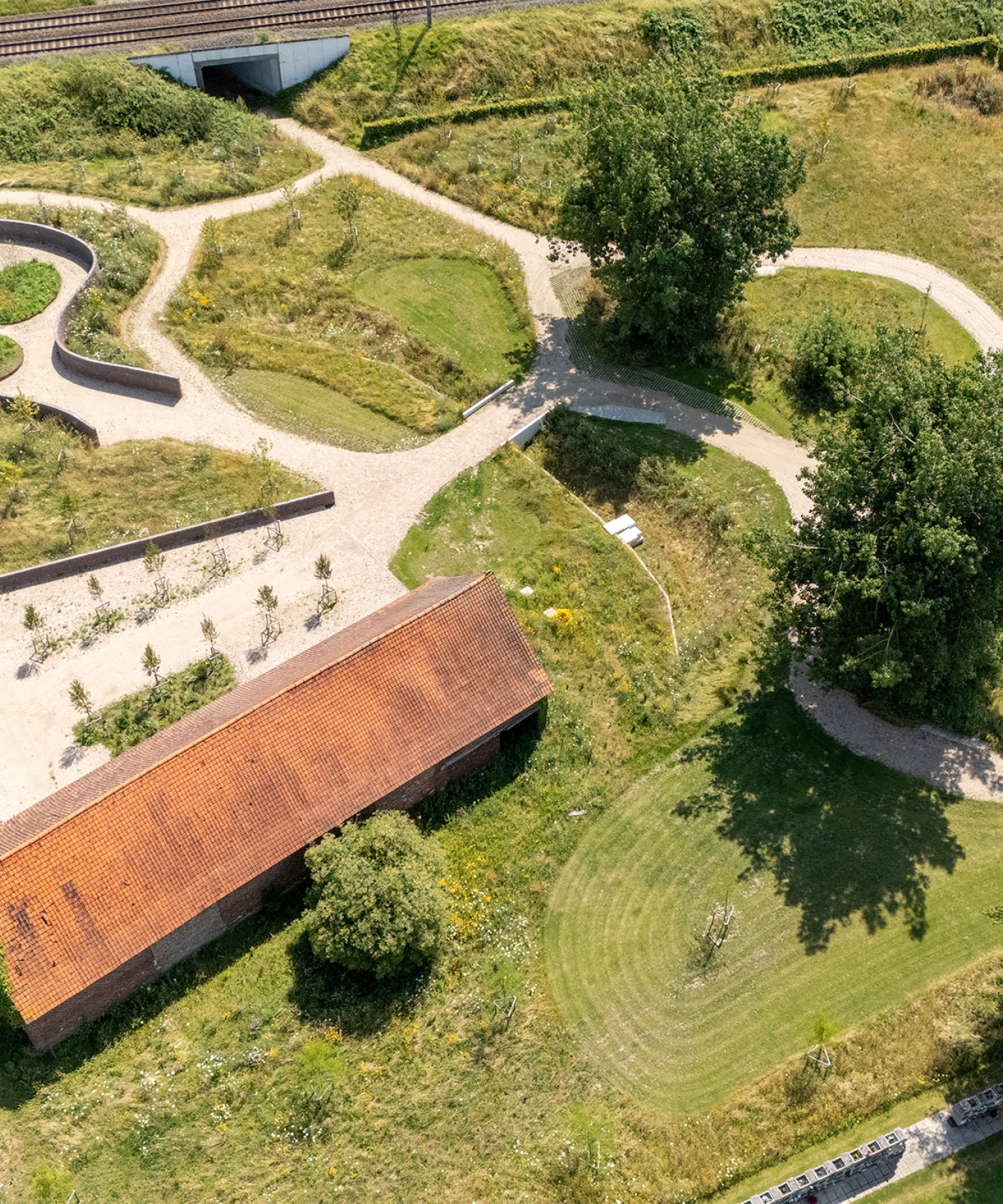 Vogelperspectief van de begraafplaats met overzicht van bloemenvelden en wandelroutes.