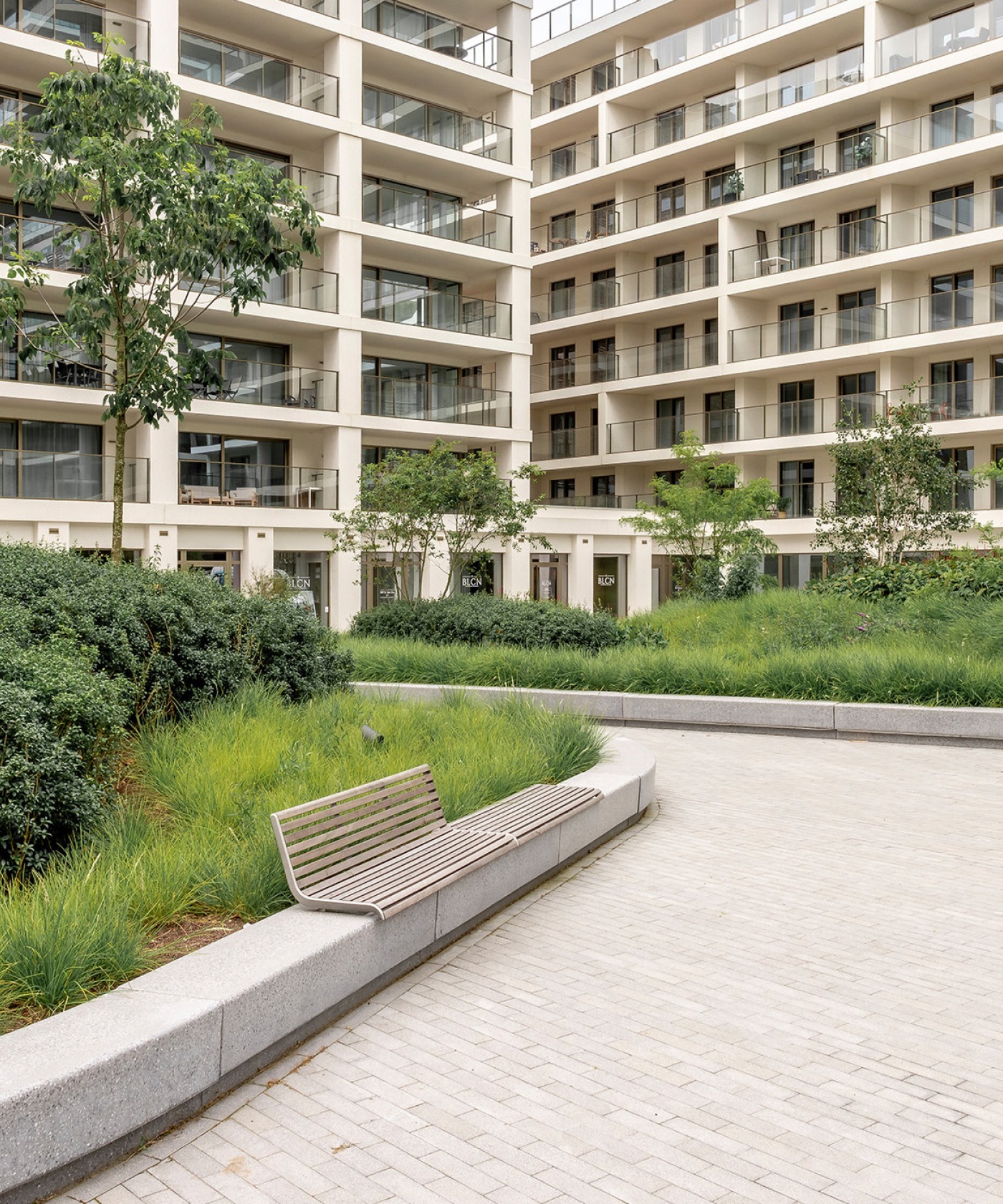Omgevingsaanleg met zitbanken en intensieve beplanting in de binnentuin van SKY Towers, Oostende