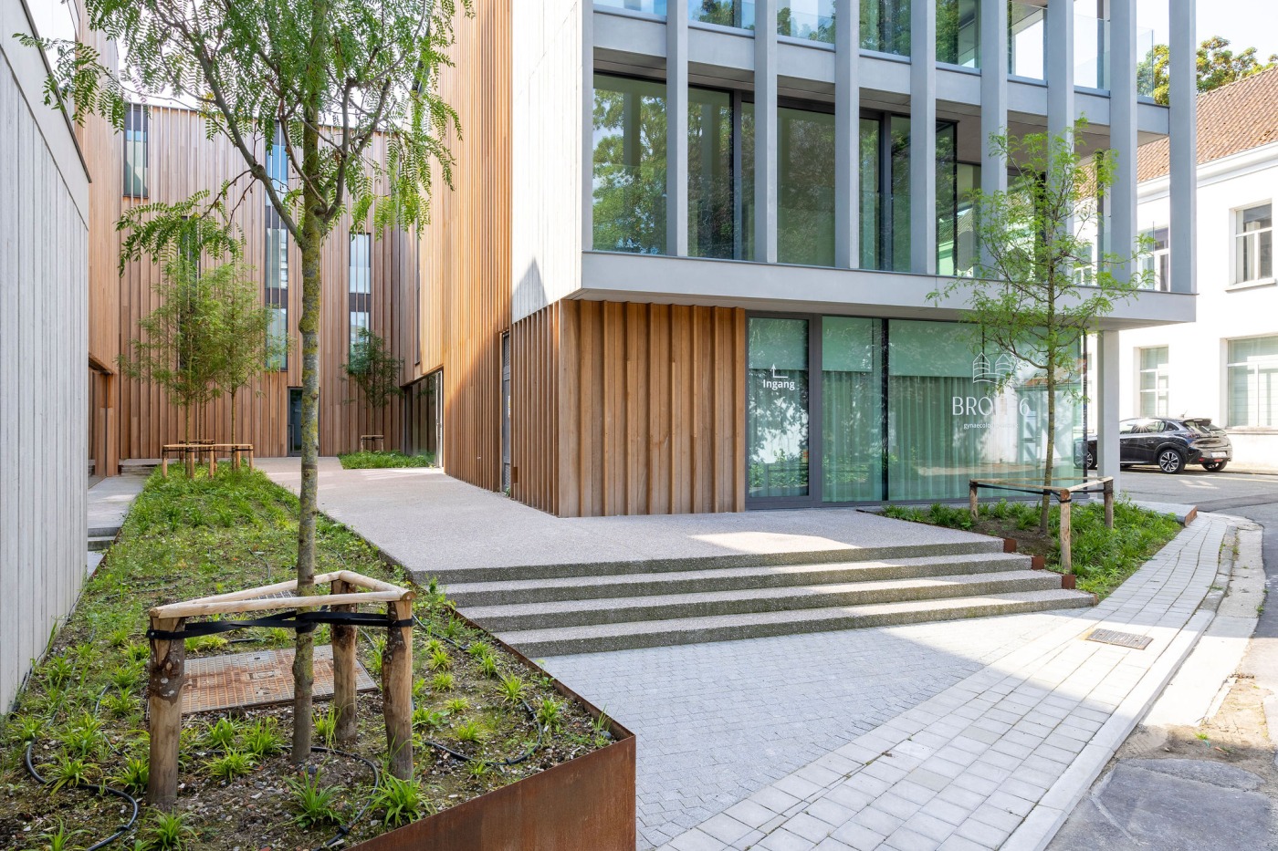 Groene entree bij het Broelhotel met houten gevelbekleding en minimalistische beplanting