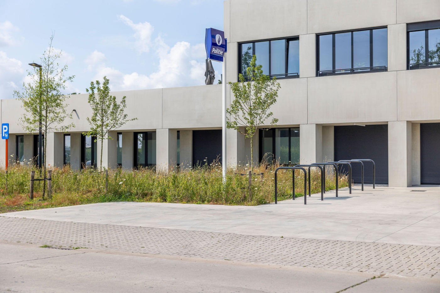 Vooraanzicht van het politiekantoor Torhout met groene landschapsinrichting.