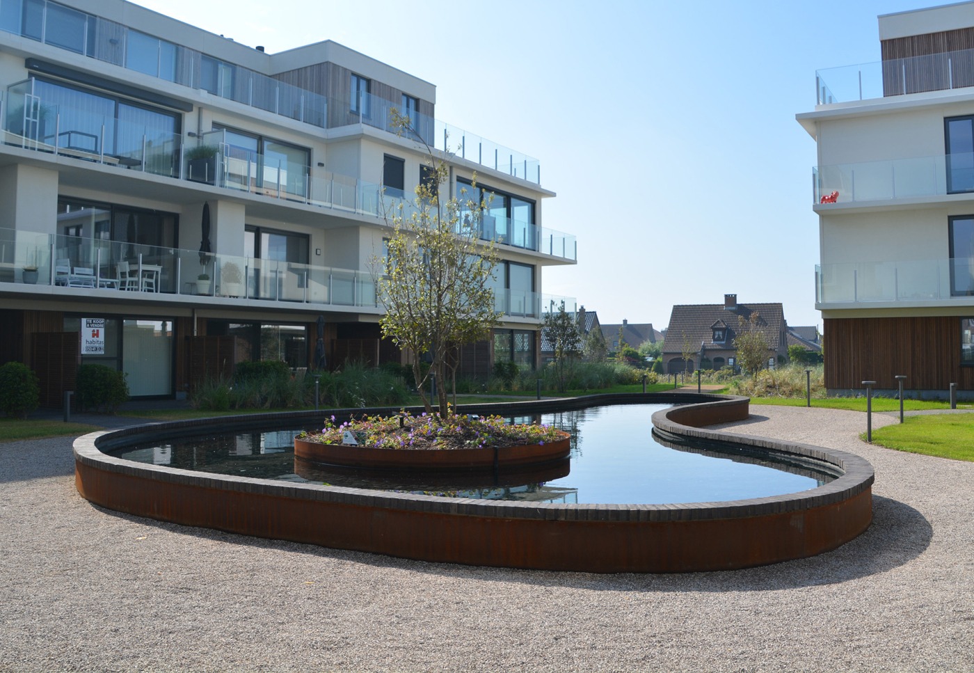 Waterpartij met bloemperken bij het Sea Gardens appartementencomplex