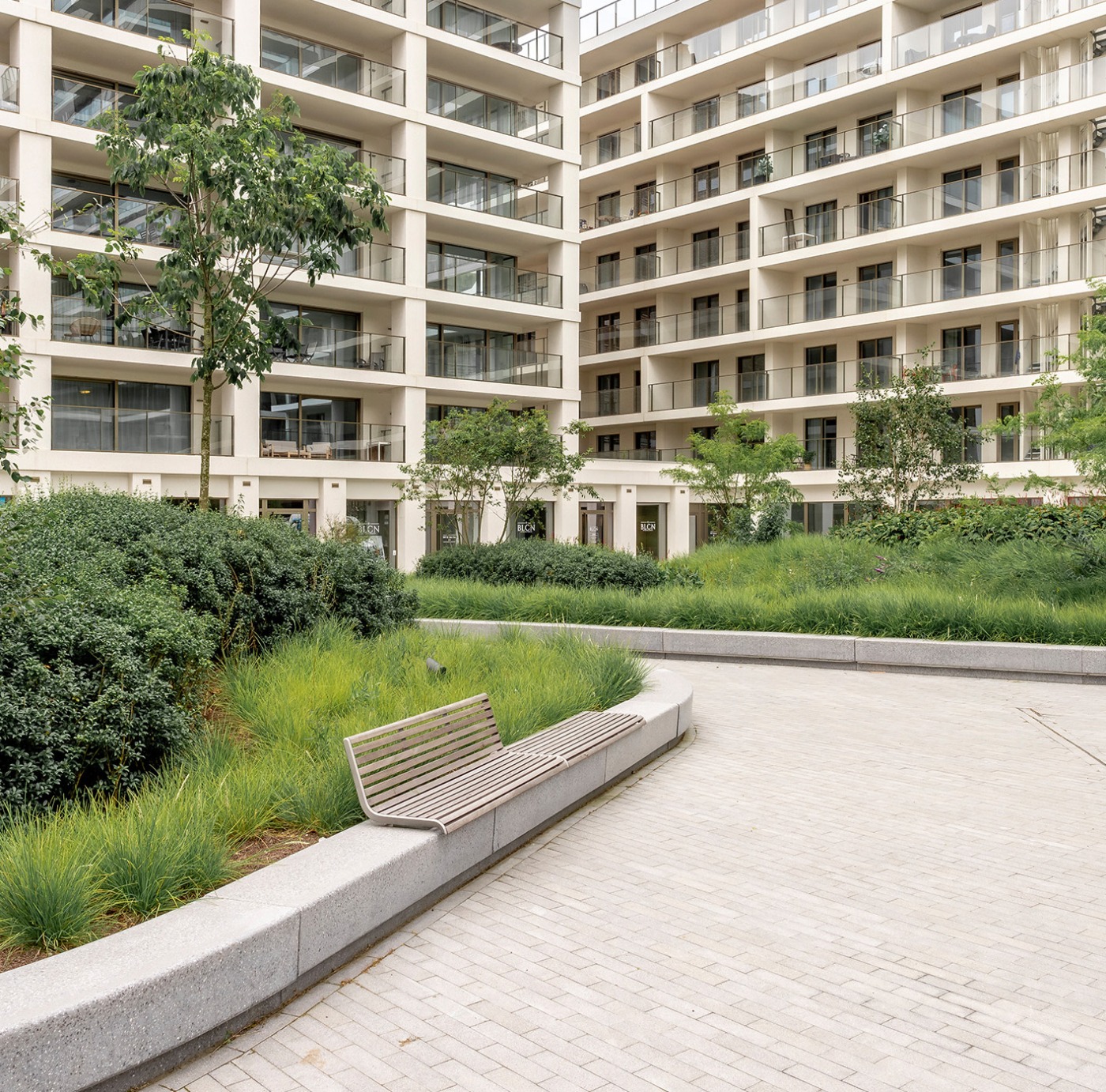 Omgevingsaanleg met zitbanken en intensieve beplanting in de binnentuin van SKY Towers, Oostende
